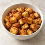 Bowl of crispy baked tofu with golden edges