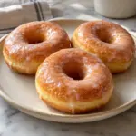 Three homemade donuts with a thin vanilla glaze