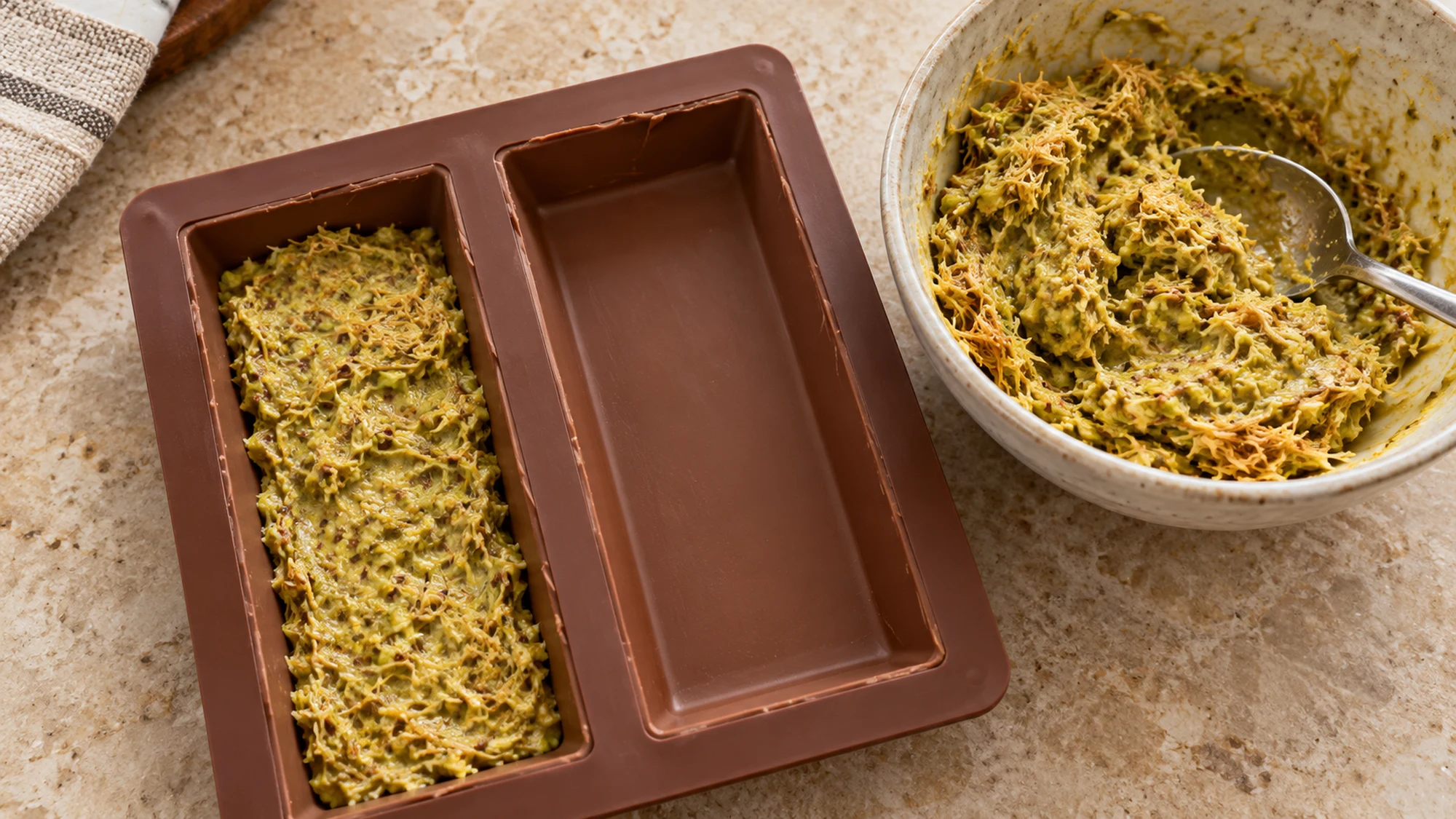 Chocolate bar molds with pistachio-kataifi filling during assembly