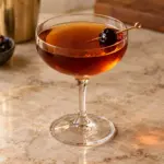 Manhattan recipe with clear amber color and cherry garnish