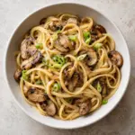 Bowl of miso mushroom pasta with scallion garnish
