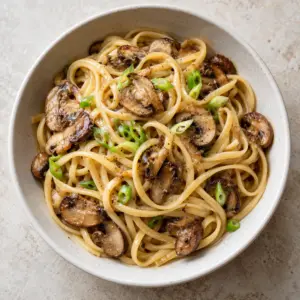 Bowl of miso mushroom pasta with scallion garnish