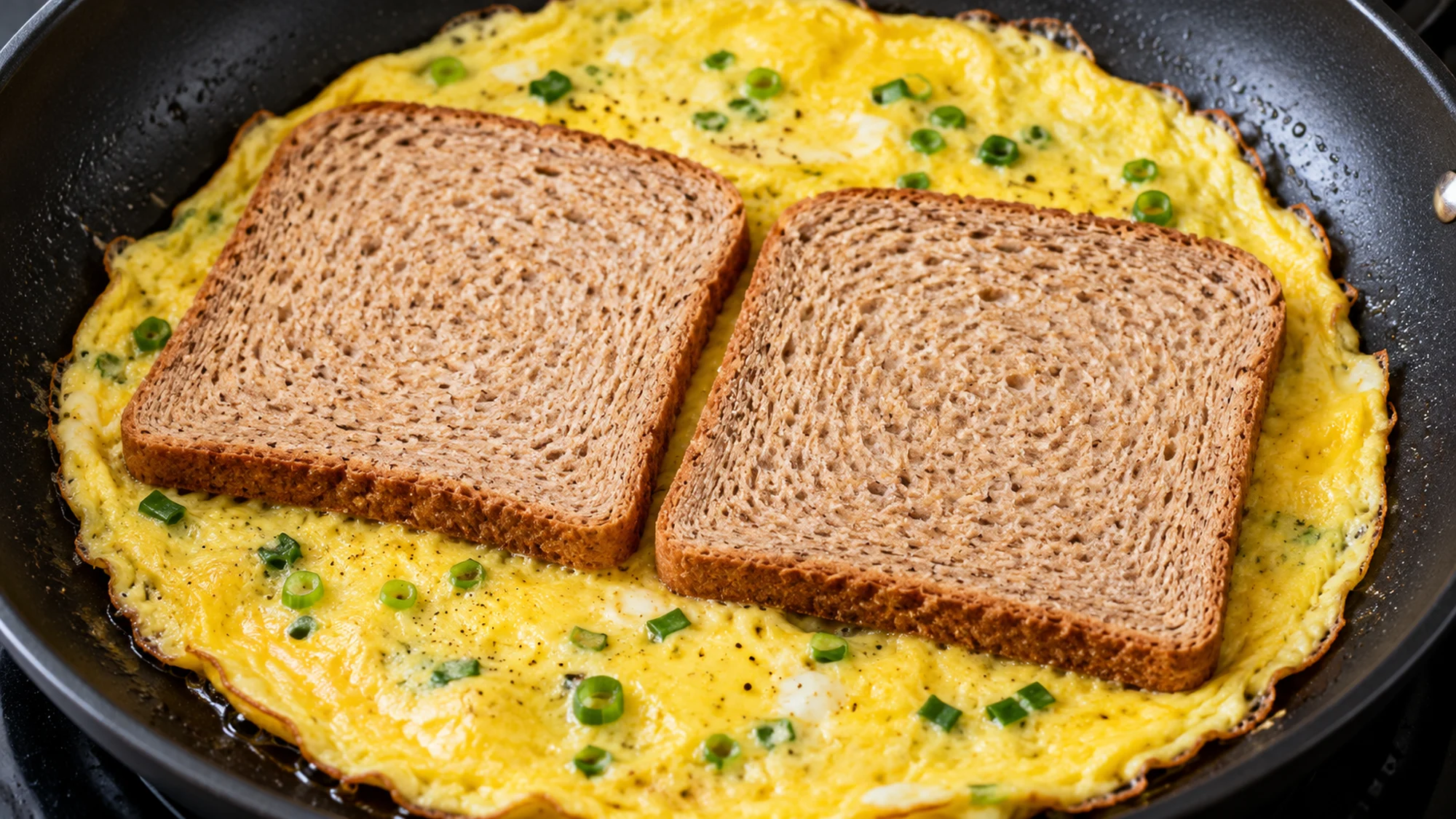 Set omelet with two bread slices in a skillet for the one-pan egg sandwich