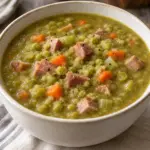 Thick pea and ham soup with diced carrots and celery