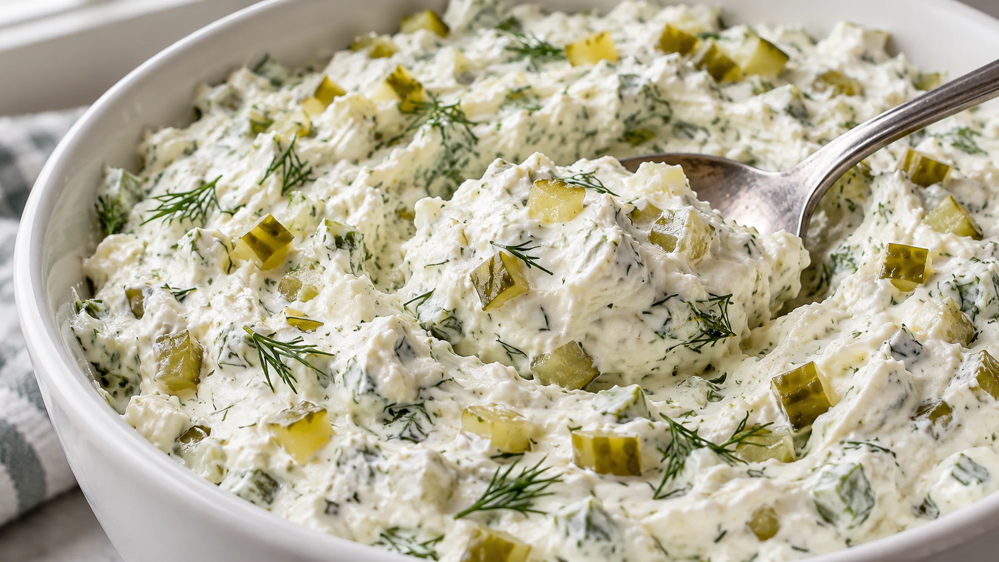 Spoon showing the thick, chopped-pickle texture of pickle dip