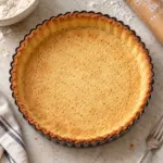 Fully baked shortcrust pastry recipe shell in a fluted tart tin