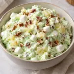 Watergate salad showing pineapple pieces and marshmallows in pistachio fluff
