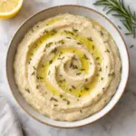Overhead bowl of white bean dip with rosemary and olive oil